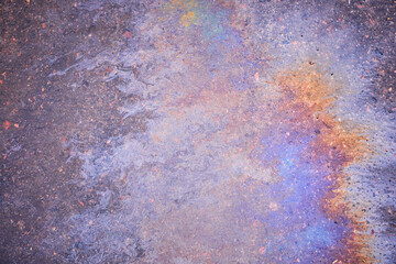 Splashes of grease on an asphalt road form a patterned foundation.