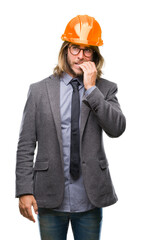 Young handsome architec man with long hair wearing safety helmet over isolated background looking stressed and nervous with hands on mouth biting nails. Anxiety problem.