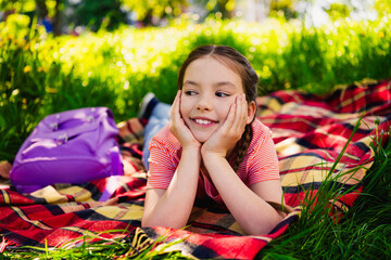 Full length photo of adorable little girl have fun outside activity lying ground picnic enjoy summer weekend pastime fresh air outdoor