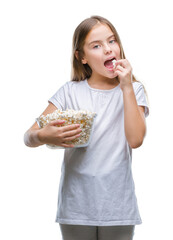 Young beautiful girl eating popcorn snack isolated background with a confident expression on smart face thinking serious