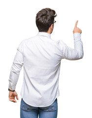 Young business man wearing glasses over isolated background Posing backwards pointing behind with...