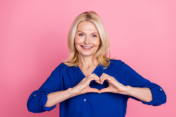 Photo portrait of pretty senior female show heart symbol wear trendy blue outfit isolated on pink...