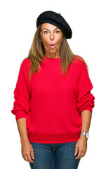 Middle age adult woman wearing fashion beret over isolated background afraid and shocked with surprise expression, fear and excited face.