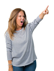 Beautiful middle age woman wearing stripes sweater over isolated background Pointing with finger surprised ahead, open mouth amazed expression, something in front