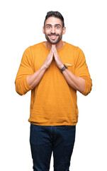 Young handsome man over isolated background praying with hands together asking for forgiveness smiling confident.