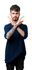 Young handsome man over isolated background Rejection expression crossing arms doing negative sign, angry face