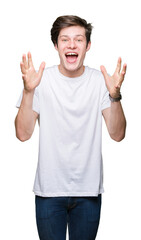 Young handsome man wearing casual white t-shirt over isolated background celebrating crazy and amazed for success with arms raised and open eyes screaming excited. Winner concept