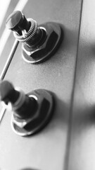 Czarna glowka gitary elektrycznej z kluczami. Metalowe struny. Zdjecie maro gitary.