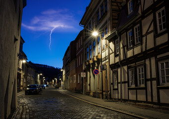 Fototapeta premium Street alley in the small town of Schwabisch Hall, with houses and buildings with typical German architecture and street lanterns, at night.