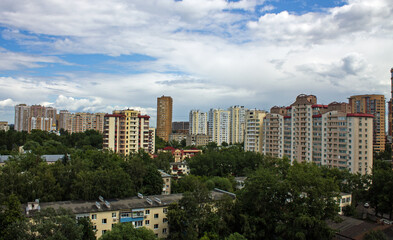 Cityscape - panoramic top view of a residential quarter with modern high-rise buildings with green trees on a sunny summer day and blue sky with white clouds in Reutov, Moscow region and copy space