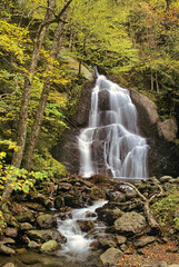 Obraz premium Autumn in Vermont. Vertical image of lovely 100-foot tall Moss Glen Falls along Deer Hollow Brook in Granville Vermont.