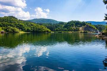 Radoinja Lake (Radoinjsko jezero)- a water gem in the Uvac Canyon, on the Zlatar mountain, reflection of a green hill and clouds in the water