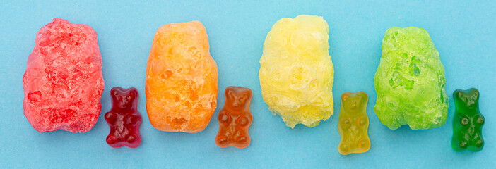 A Line of Freeze Dried Gummy Bear Shaped Candies Isolated on a Blue Background