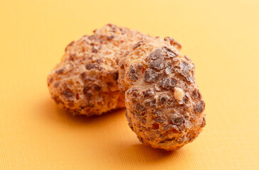 Freeze Dried Milk Chocolate Covered Caramel Disks on Yellow Background