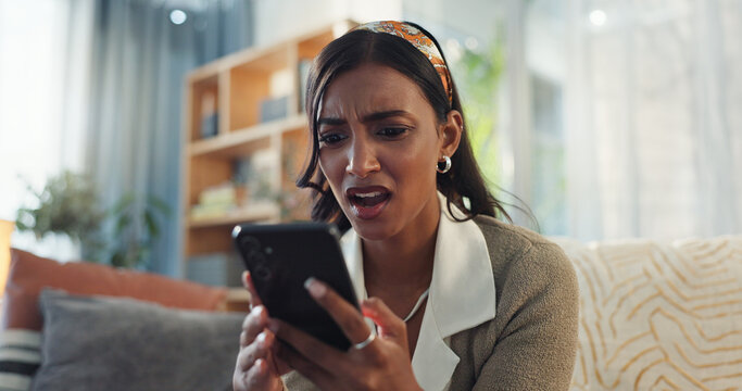 Indian woman, home and shocked on smartphone in sofa on website with fake news and online scam. Female person, gen z and frustrated or stress with cybercrime in living room for fraud or hacking