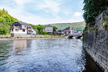 River Ourthe between brick walls of pedestrian promenade along river, buildings, houses, bridges...