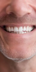 Obraz premium A man with a white smile showing his teeth. The man's teeth are clean and white, and he is smiling