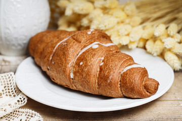 French croissant made of puff pastry on a wooden table.