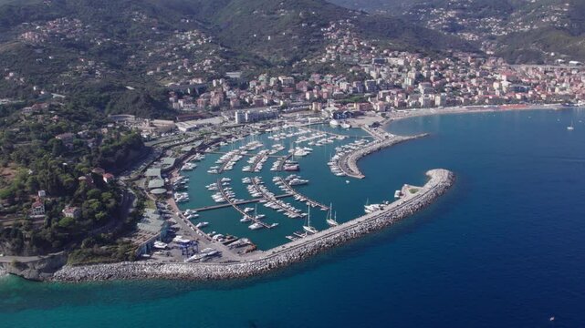 Aerial view circling around the Marina di Varazze of Celle Ligure in the Italian region Liguria with blue sea