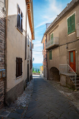 Narrow alley in the small medieval town of Fosdinovo in Tuscany, Italy with view at the Mediterranean Sea
