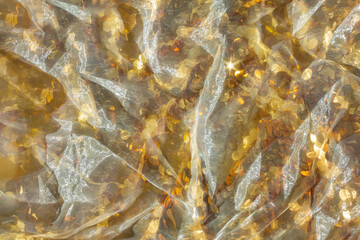 Gold sequin background with white silk folds on top.