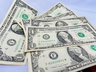 Notas de dolares em diversos valores com fundo branco e bandeira dos Estados Unidos da America.