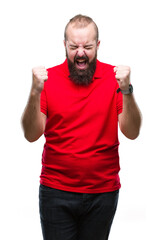 Young caucasian hipster man wearing red shirt over isolated background excited for success with arms raised celebrating victory smiling. Winner concept.