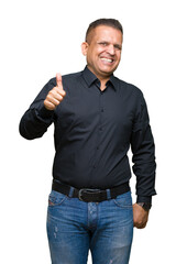 Handsome middle age arab business man over isolated background doing happy thumbs up gesture with hand. Approving expression looking at the camera showing success.