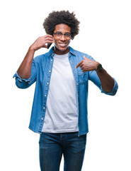 Afro american man talking on the phone over isolated background with surprise face pointing finger to himself