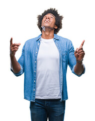Afro american man over isolated background amazed and surprised looking up and pointing with...