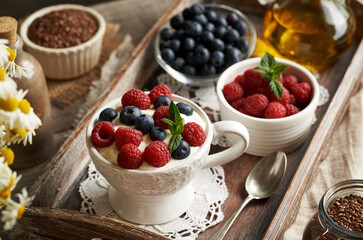Cottage cheese with flax seed oil with blueberries and raspberries on a table