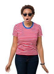 Beautiful young african american woman wearing sunglasses over isolated background afraid and shocked with surprise expression, fear and excited face.