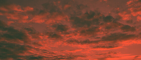 red and dark clouds beautiful sunset ambiance with large yellow and orange sun in he sky surface hills