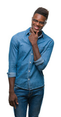 Fototapeta premium Young african american man over isolated background looking confident at the camera with smile with crossed arms and hand raised on chin. Thinking positive.