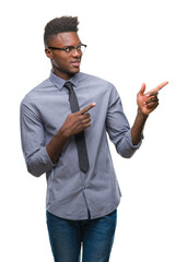 Young african american business man over isolated background smiling and looking at the camera pointing with two hands and fingers to the side.