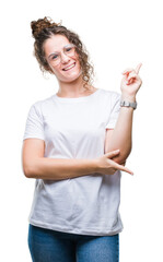 Beautiful young brunette curly hair girl wearing glasses over isolated background with a big smile on face, pointing with hand and finger to the side looking at the camera.