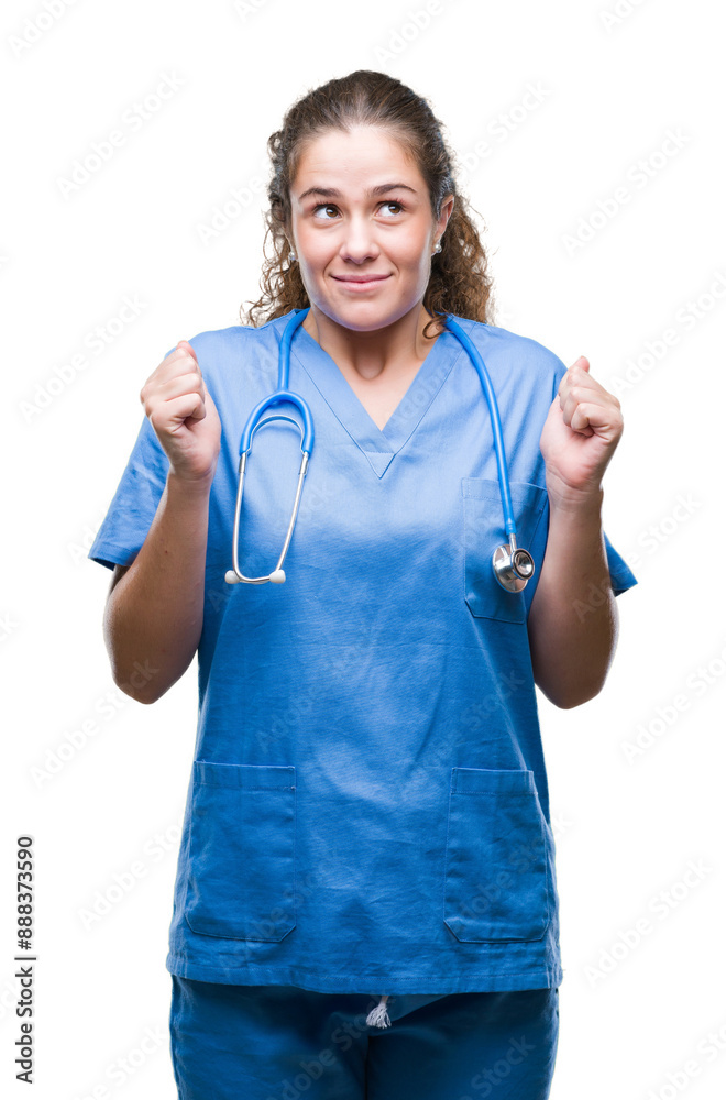 Poster Young brunette doctor girl wearing nurse or surgeon uniform over isolated background excited for success with arms raised celebrating victory smiling. Winner concept.