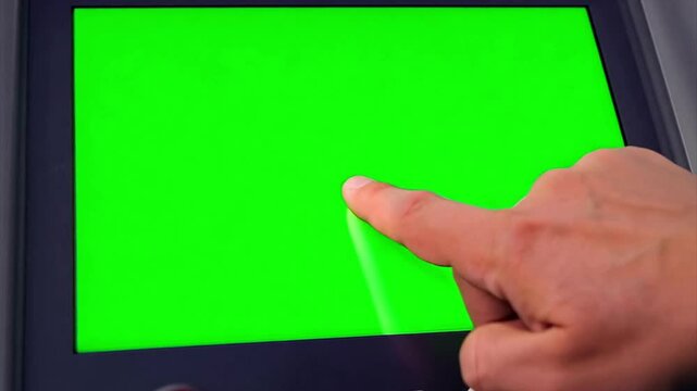 Macro close up of a finger using a touchscreen on an electronic voting machine during an election. Touch screen is a chroma green screen.