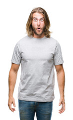 Obraz premium Young handsome man with long hair over isolated background afraid and shocked with surprise expression, fear and excited face.
