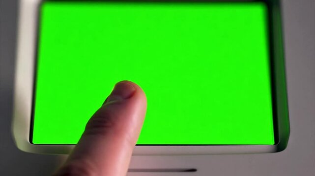 Macro close up of a finger using a touchscreen on an electronic voting machine during an election. Touch screen is a chroma green screen.