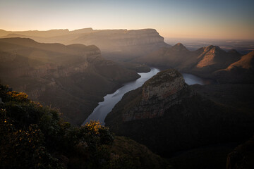Beautiful cinematic landscape  with a stunning view of a mountain range with the Blyde river running through the range. Taken from a hilltop looking down into the valley over the river.
