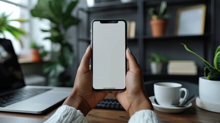 Closeup of woman holding a blank screen smartphone in a home office