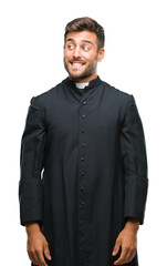 Young catholic christian priest man over isolated background smiling looking side and staring away thinking.