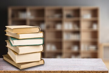 stack of books in library on wooden table