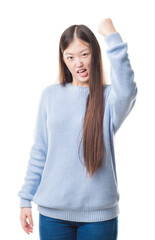 Fototapeta premium Young Chinese woman over isolated background angry and mad raising fist frustrated and furious while shouting with anger. Rage and aggressive concept.