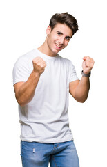 Young handsome man wearing white t-shirt over isolated background very happy and excited doing winner gesture with arms raised, smiling and screaming for success. Celebration concept.