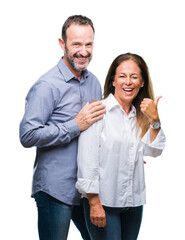 Middle age hispanic business couple over isolated background smiling with happy face looking and pointing to the side with thumb up.