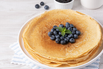 Crepes, thin pancakes with blueberry jam and fresh berries
