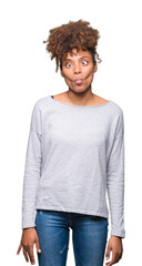 Beautiful young african american woman over isolated background making fish face with lips, crazy and comical gesture. Funny expression.