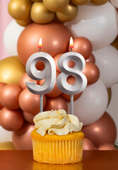 Cupcake with birthday candle on balloons background - Number 98